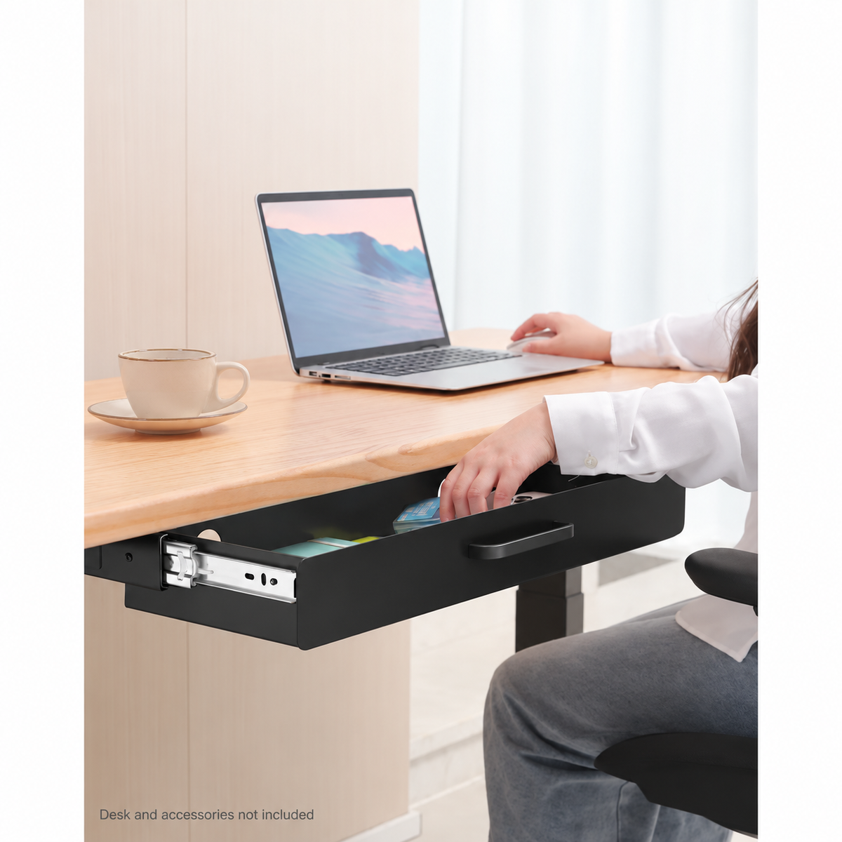 Person using the open black under-desk drawer at a warm wood workstation. Desk, laptop, chair and accessories not included.